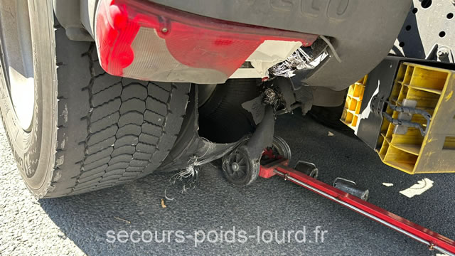 Équipe réparant un pneu crevé sur un poids lourd